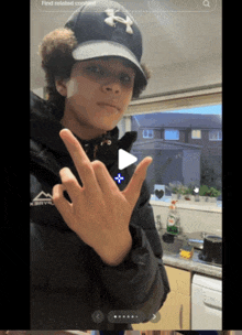 a person wearing a black jacket and a black hat with the letter x on it