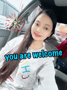a woman in a car with the words " you are welcome " on the bottom right