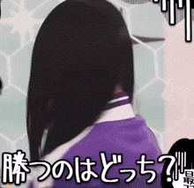a woman in a purple shirt is standing in front of a wall with japanese writing