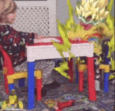 a child is sitting at a table with a toy dragon ball z character behind them .