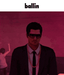 a man in a suit and tie is standing in front of a red background with the word ballin on it