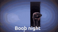 a man is bending over in front of a door that says boob night on it