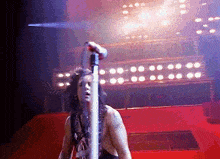 a man singing into a microphone on a stage
