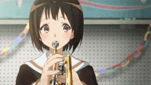 a girl is playing a trumpet in front of a wall with dots