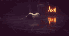 a man is kneeling in front of a fire