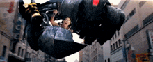 a man is riding a robot in a city with a sign that says ice