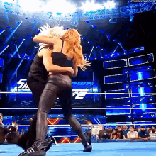 a couple of women are wrestling in a ring .