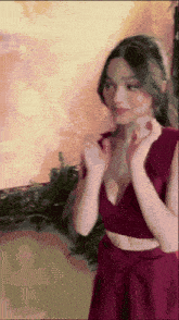 a woman in a red dress is standing with her hands on her face