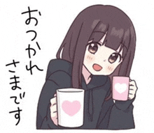 a girl in a black hoodie is holding a pink cup with a heart on it .