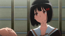 a girl with a red bow on her head is being touched by someone 's hand