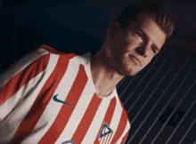 a man wearing a red and white striped shirt with a nike logo