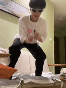 a person wearing sunglasses and a white shirt with a heart on it