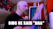 a bald man is standing in a room with his arms outstretched and the words `` omg he said aha '' above him .