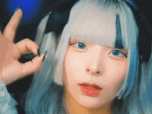 a woman with white hair and blue eyes is making a peace sign