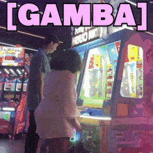 a man and a girl are playing an arcade game with the words [ gamba ] above them
