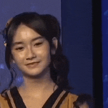 a young woman is smiling and looking at the camera while wearing a headband .