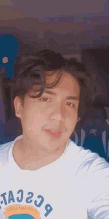 a young man taking a selfie with a white shirt that says ta229 on it
