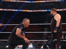 two wrestlers are standing in a wrestling ring with a banner that says summerslam