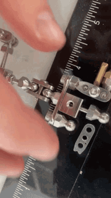 a person is measuring a piece of metal with a ruler that goes up to 9 inches
