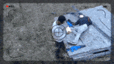 a man is laying on a wooden plank with a red rec button in the upper right corner