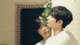 a man standing in front of a mirror with a reflection of another person