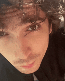 a close up of a man 's face with a black shirt