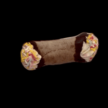 a close up of a chocolate cannoli with sprinkles on top