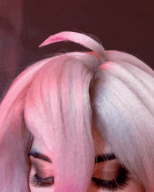 a close up of a woman 's hair with a pink fringe