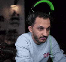 a man with a beard wearing headphones and a sweatshirt that says op on it