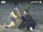 a man in a yellow shirt is kneeling down next to another man in a black jacket