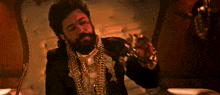 a man with a beard is wearing a lot of gold