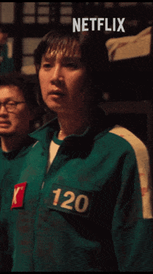 a man in a green jacket with the number 120 on his chest