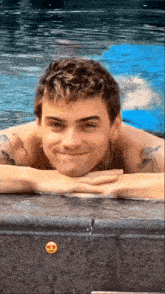 a young man is laying in a swimming pool with his head on the edge .