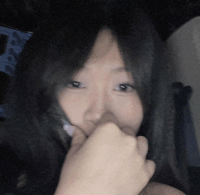 a woman covering her mouth with her hand in front of a computer screen