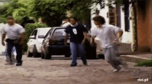 a group of people are running down a street with a sbt logo in the corner