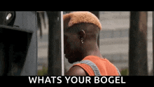 a man with a shaved head is standing in front of a phone booth .