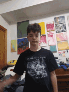 a boy is wearing a silver city idaho shirt