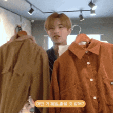 a man is standing in front of a display of clothes with a sticker that says ' oh ? ' on it