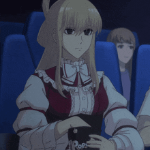 a girl in a red and white dress is holding a popcorn bucket