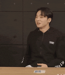 a man wearing a black sweatshirt with a peace sign on it