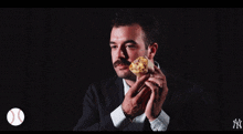 a man with a mustache is holding a sandwich in front of a 93 option 1 sign
