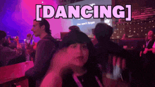 a group of people are dancing in front of a screen that says dancing