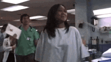 a woman in a hospital gown is crying and holding a piece of paper