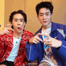 two young men are making funny faces and one of them is wearing a blue jacket with nike on it