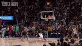 a basketball game is being played on a court with a crowd of people watching .