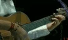 a close up of a person playing a guitar in a dark room .