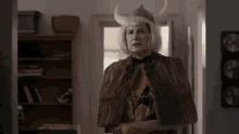 a woman is wearing a viking hat and a fur coat