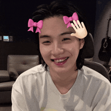 a woman wearing a white shirt with a pink bow on her head