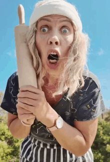 a woman with a bandage on her head is holding a rolling pin