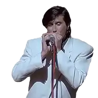 a man in a white jacket is playing a harmonica into a microphone